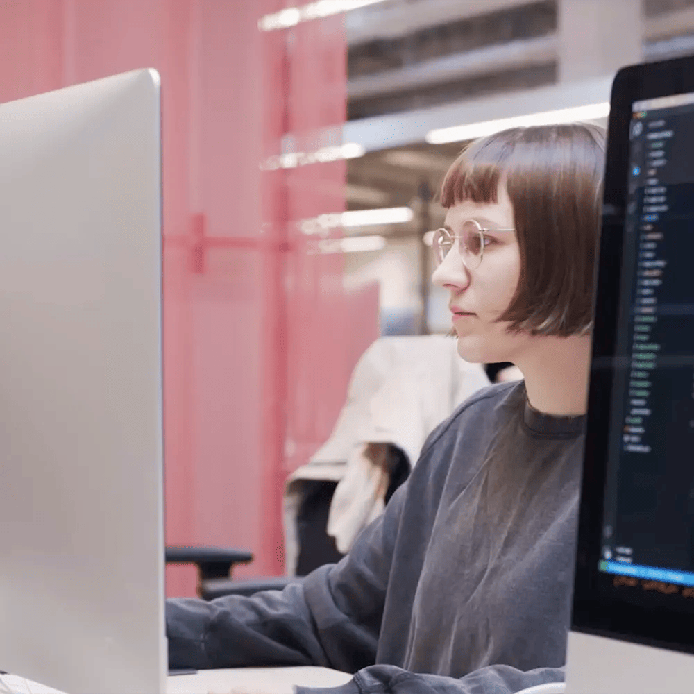 Person working on a laptop in a modern tech workspace at Hive Helsinki